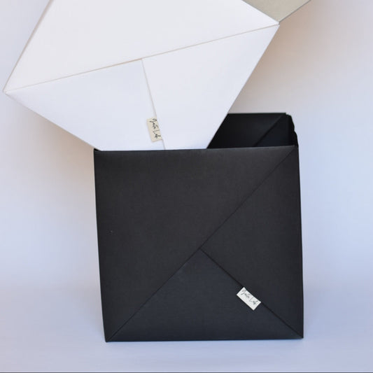 Three handmade Origami baskets in washable paper in coolers stone, warm white and black charcoal on a white background - Gaita Lab